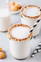 Poster - Vanilla milkshake with crispy cookies in glass mason jar on gray background