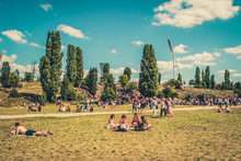 Cityscape Blur Concept - People Enjoying Sunny Summer Day On Meadow In Crowded Park (Mauerpark) In Berlin City