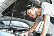 © S photographer - Car Repair Concept. Asian people are repairing cars on the roadside. Asian guy fixes car with confidence