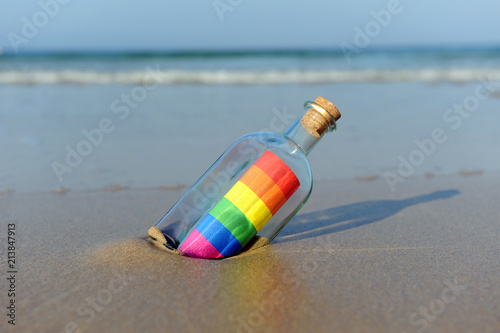 Fotografía Mensaje del orgullo gay en una botella a la orilla del mar