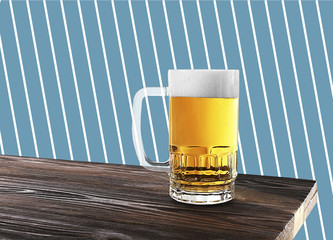 Wall Mural - Glass mug of beer on wooden table against patterned background