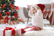 © New Africa - Cute baby in Santa hat on floor at home. Christmas celebration