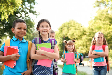 Poster - Cute little children with backpacks and notebooks outdoors. Elementary school