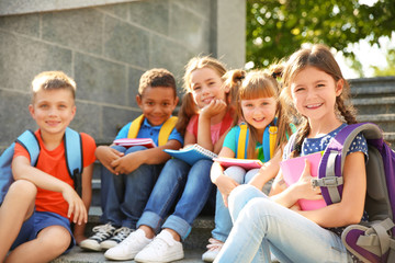 Poster - Cute little children with backpacks and notebooks outdoors. Elementary school