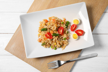 Plate with tasty boiled rice and vegetables on table, top view