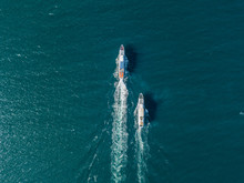 Top View Of Two Cruise Ships In The Open Sea, One Outrunning Another