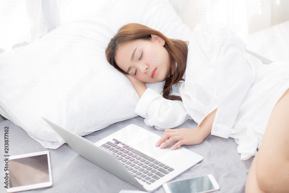 Beautiful young asian woman with laptop lying down in bedroom, girl ...