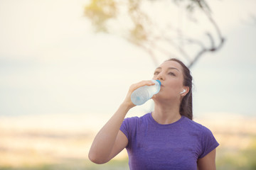  Young girl drinking water during morning jogging