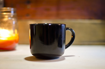 Wall Mural - A solo blank black coffee mug on the old workshop bench. 