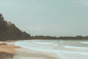 Vintage photo of beautiful beach landscape with cloudy sky and sea with waves.