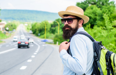 Wall Mural - Adventure spirit. Hitchhiker try to stop transport to get to destination. Man at edge of highway looking for transport. Hitchhiking means transportation gained asking strangers for ride in their car