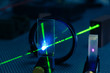 Green laser on optical table in a quantum optics lab.