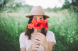 © Westend61 - Woman holding a bouquet of red poppies in spring