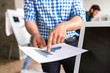 © pantovich - Businessman in checkered shirt in the office is pointing the finger at schedule of revenues closeup