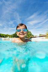 Wall Mural - Cute boy enjoying summer, swimming in the pool