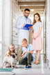 © LIGHTFIELD STUDIOS - children and mother choosing pug dog for adoption at animals shelter