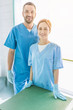 © LIGHTFIELD STUDIOS - smiling two veterinarians standing in uniform and looking at camera at veterinary clinic
