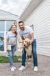 © LIGHTFIELD STUDIOS - smiling male and female volunteers of animals shelter palming labrador and looking at camera