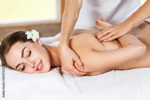 Beautiful woman lying on massage table and enjoying massage. Lerretsbilde