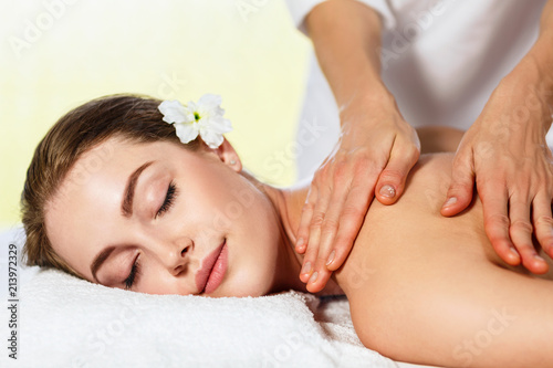 Fotografering Beautiful woman lying on massage table and enjoying massage.