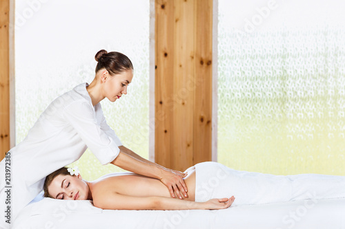 Beautiful woman lying on massage table and enjoying massage. Lerretsbilde