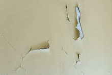 Background Of An Old Wall With A Peeled Oil Paint Of Beige Color In A Bright Room Inside The House