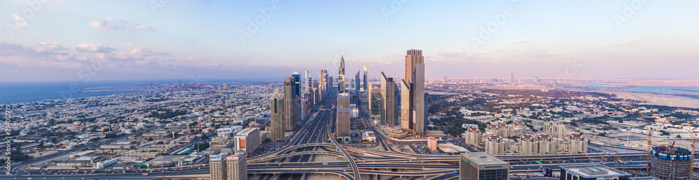 DUBAI, UAE - FEBRUARY 21, 2014. Panorama aerial view on Dubai main street - Sheikh Zayed Road and skyscrapers in evening on sunset - obrazy, fototapety, plakaty 