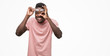 © Krakenimages.com - Young african american man wearing pink t-shirt doing ok gesture with hand smiling, eye looking through fingers with happy face.