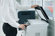 Bussiness man Hand press button on panel of printer scanner or laser copy machine in office