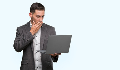 Sticker - Handsome young man using computer laptop cover mouth with hand shocked with shame for mistake, expression of fear, scared in silence, secret concept