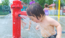 Happy Toddler Boy Playing In Water Park Spray Ground