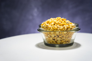 Poster - Peas dry in glass bowl on a white round table background.