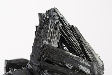 Wall Mural - Extreme close up of black tourmaline mineral isolated over white background in focus stacking technique