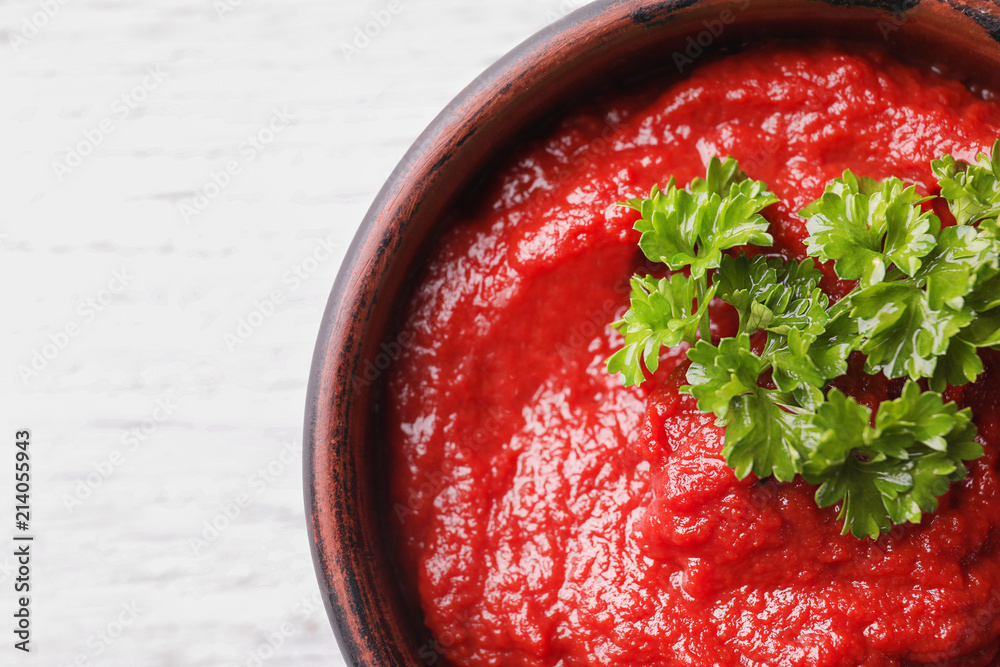 Bowl of delicious tomato sauce on table, closeup