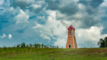 Wooden Windmill On The Background Of A Cloudy Sky