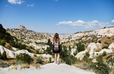 Wall Mural - Young girl looking at the landscape. She admires the nature of Cappadocia. 