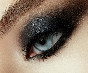 Close up view of young beautiful woman. Perfect skin and evening makeup. Silver smokey eyes. Macro studio shot. Sensuality, passion, cosmetology and modern makeup concept.