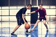 Two teenage boys playing basketball together on the court