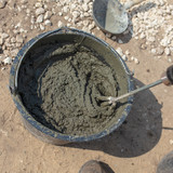 Fototapeta Pomosty - The worker mixes the concrete mixture at the construction site