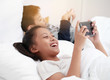 © alexzeer - Portrait of cute adorable white asian girl and toddler boy sitting in bed playing with digital tablet with funny face expression. Candid lifestyle early development. .