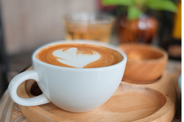 Wall Mural - Coffee in a white cup and tea on the table.