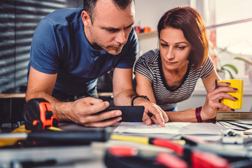 Couple looking at blueprints during kitchen renovation