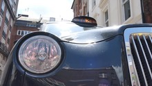 Low Angle View Of A Headlight And Taxi Sign On The Cab. London.