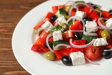 Plate with delicious fresh salad on table, closeup