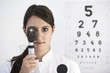 canvas print picture - Portrait Augenärztin mit eingeschaltetem Ophthalmoskop und Lichtstrahlen