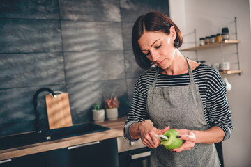 Wall Mural - Woman peeling apples in the kitchen