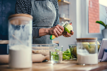 Wall Mural - Woman peeling apples in the kitchen