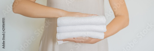 Fotografía A woman is holding a stack of white towels
