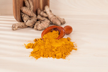 Wall Mural - Turmeric powder and fresh turmeric on wooden background