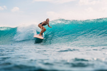 Surf Woman On Surfboard During Surfing. Surfer And Ocean Wave